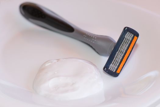 One razor along with shaving foam isolated on white background.