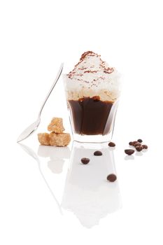 Viennese coffee. Espresso coffee topped with whipped cream and sprinkled with chocolate with coffee beans, brown sugar and spoon isolated on white background.