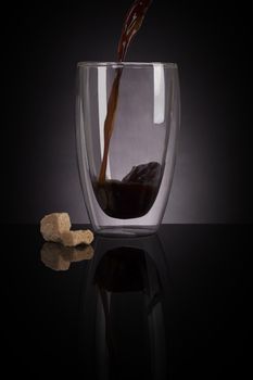 Filter coffee in glass on dark black background. Delicious coffee drinking.