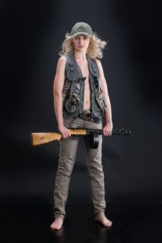 Young blonde woman dressed in military style with weapon