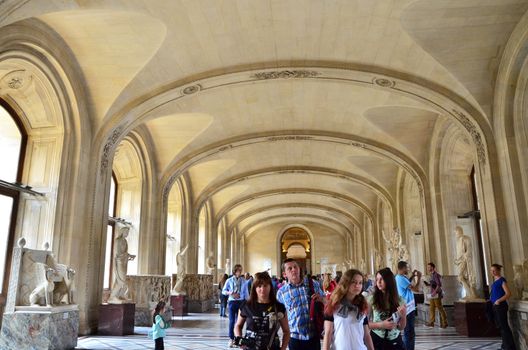 Paris, France - May 13, 2015: Tourists visit Interior of Louvre museum on May 13, 2015 in Paris. Louvre is one of the biggest Museum in the world, receiving more than 8 million visitors each year. 