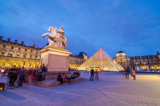 Paris, France - May 14, 2015: Tourists visiting Louvre museum at dusk on May 14, 2015 in Paris. This is one of the most popular tourist destinations in France.