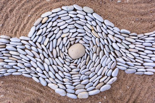 Twisting of stones on a sandy beach