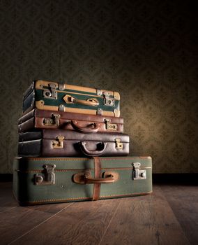 Pile of leather vintage suitcases, retro wallpaper on background.