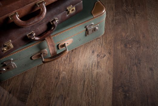 Vintage luggage close-up on dark hardwood floor, travelling concept.