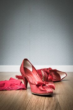 Female red shoes and lingerie on floor, sensuality and seduction concept.