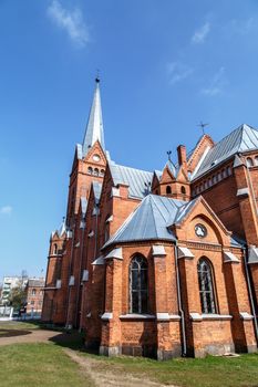 Side view of  Evangelical Lutheran Marthin Luther Cathedral in Dougavpils, Latvia, on cloudy blue sky background.