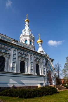 Side view of Orthodox Ss Boris and Gleb Cathedral in Dougavpils, Latvia, on blue Cloudy sky background.