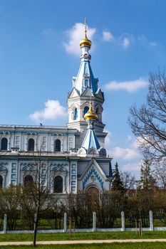 Front view of Orthodox Ss Boris and Gleb Cathedral in Dougavpils, Latvia, on blue cloudy sky background.