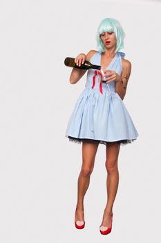 Attractive model woman in blue wig and red high heels pouring wine in a glass isolated on white