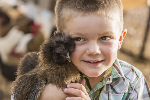 Smiling young boy holding fancy show chicken