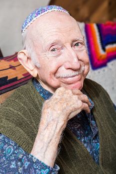 Elderly gentleman wearing a yarmulke smiling at the camera