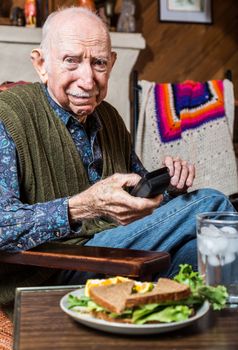 Older gentleman looking unhappily at a sandwich