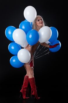 Young nude woman with a bunch of white and blue air balloons on isolated background