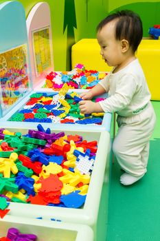 An Asian Chinese baby playing puzzle at indoor playground.