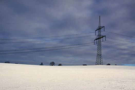 winter landscape and mast electrical wiring and gloomy sky