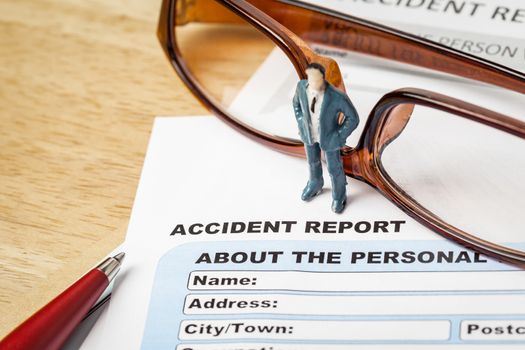 Accident report application form and businessman with pen and eyeglass, business insurance and risk concept; document is mock-up
