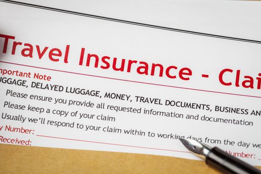 Travel Insurance Claim application form and human hand with pen on brown envelope, business insurance and risk concept; document is mock-up