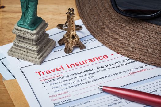 Travel Insurance Claim application form and hat with eyeglass and pen on brown envelope, business insurance and risk concept; document and plane is mock-up