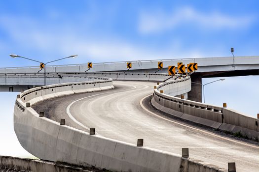 Highway asphalt road curve and traffic sign with blue sky background