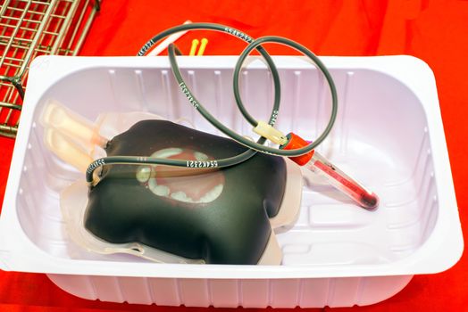 Close up bag of blood and plasma and rubber tube isolated on Red background