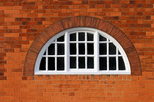 Oval window on a modern red brick building.