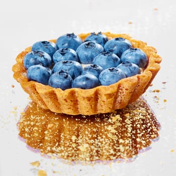 Tartlet with fresh blueberries. Background with copy space.