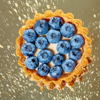 Tartlet with fresh blueberries. Background with copy space.