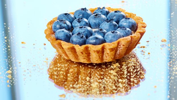 Tartlet with fresh blueberries. Background with copy space.