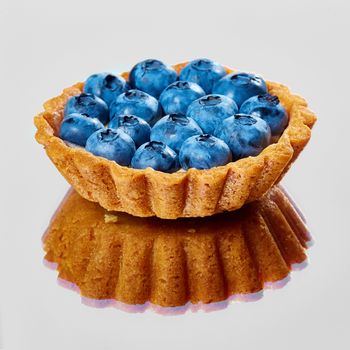 Tartlet with fresh blueberries. Background with copy space.