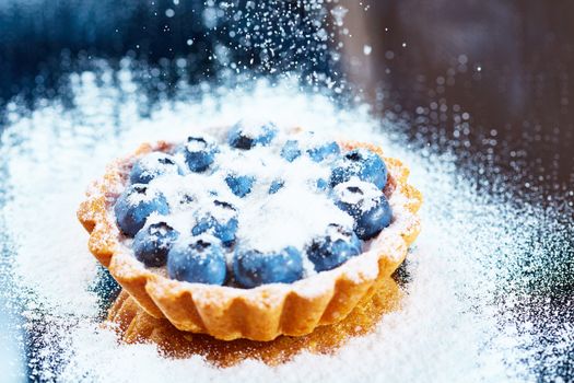 Tartlet with fresh blueberries. Background with copy space.