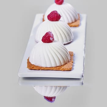 Two pink raspberry mousse desserts on a plate