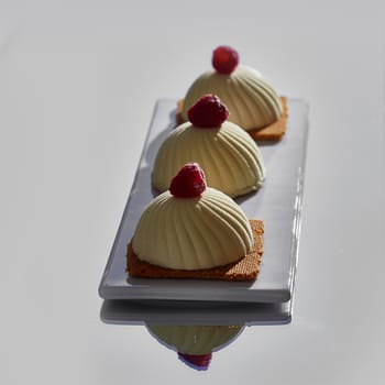 Two pink raspberry mousse desserts on a plate