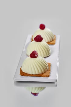 Two pink raspberry mousse desserts on a plate
