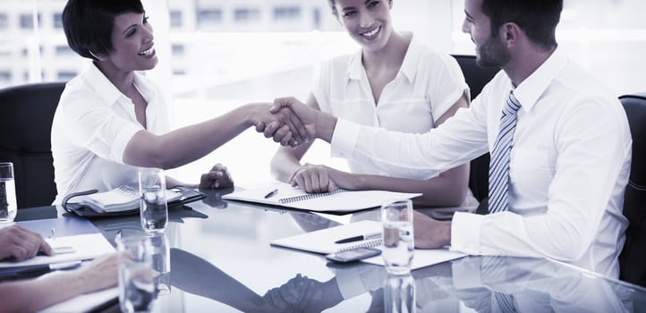 Side view of executives shaking hands after a business meeting in the office