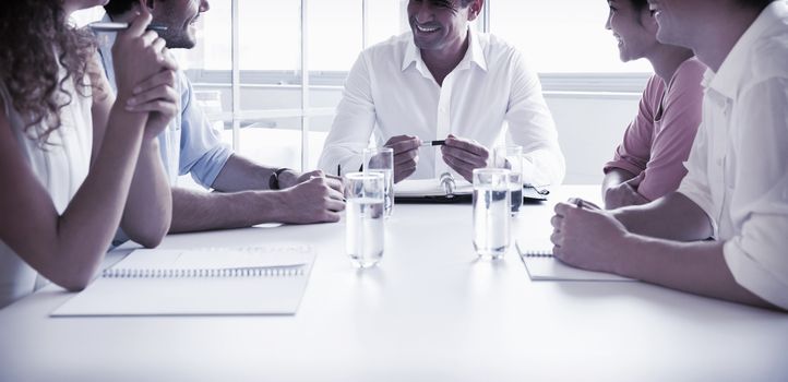 Smiling business people in meeting at conference table in office