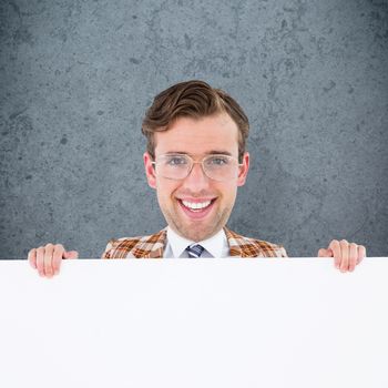 Geeky businessman showing card against dirty old wall background