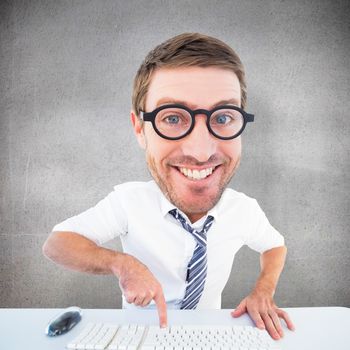 Geeky businessman typing against grey room