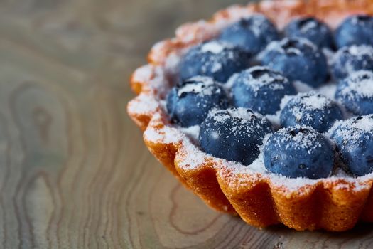 Tartlet with fresh blueberries. Background with copy space.