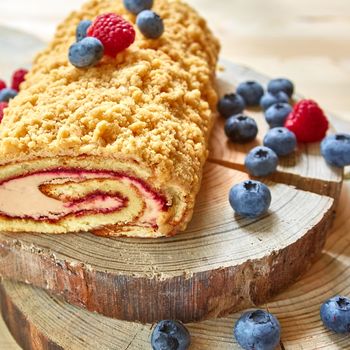 bright colorful cake roll on wood with berry. Shallow dof