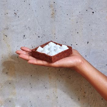 Dessert in a hand on a concrete background with copy space