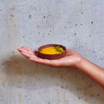 Dessert in a hand on a concrete background with copy space
