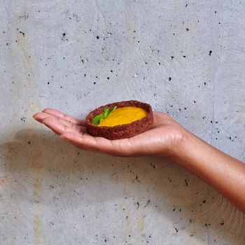 Dessert in a hand on a concrete background with copy space