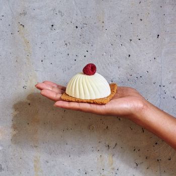 Dessert in a hand on a concrete background with copy space