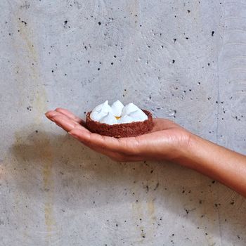 Dessert in a hand on a concrete background with copy space