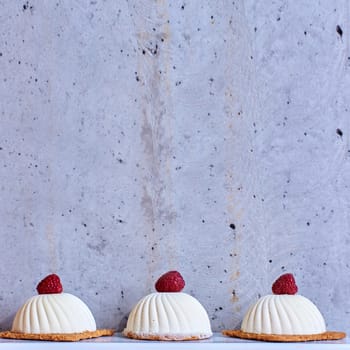 Two pink raspberry mousse desserts on a plate