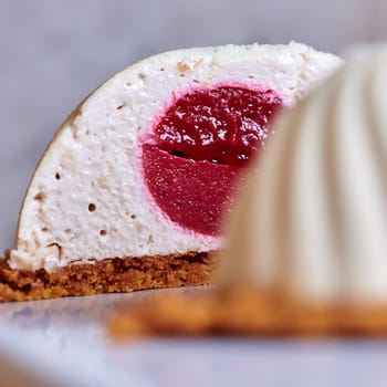 Two pink raspberry mousse desserts on a plate