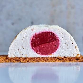 Two pink raspberry mousse desserts on a plate