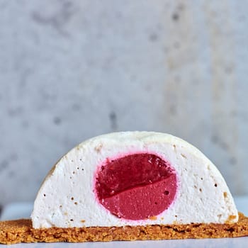 Two pink raspberry mousse desserts on a plate