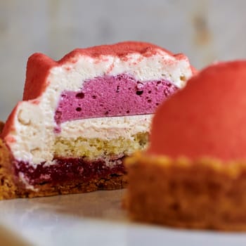 Two pink raspberry mousse desserts on a plate